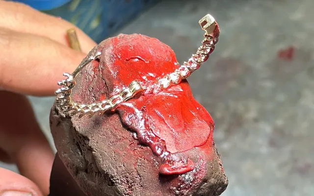 Diamond earrings held in red setter's shellac for stone setting