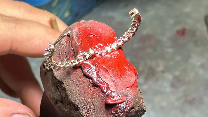 Diamond earrings held in red setter's shellac for stone setting